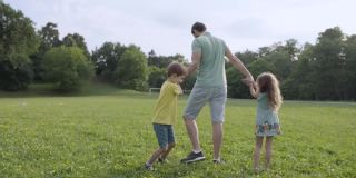 爸爸和孩子们在公园里转圈圈玩