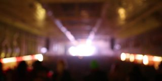 模糊的视频背景与闪烁的迪斯科灯拍摄在夜总会跳舞的人在舞池。