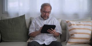 人像亚洲老人使用数码平板电脑搜索网上购物