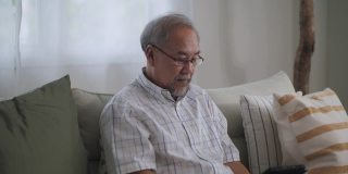 一个老人在家里用数码平板电脑打视频电话