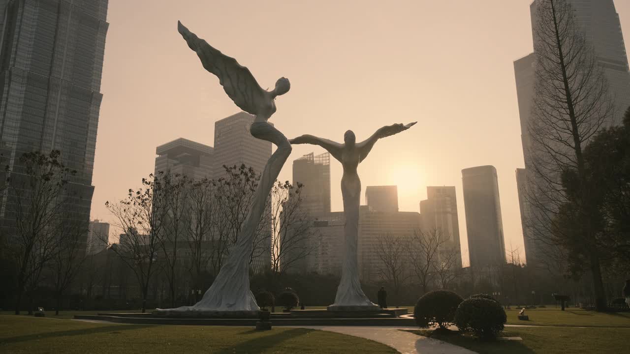 日落时分，上海陆家嘴中心绿地上的飞行双天使雕塑