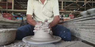 慢镜头，亚洲华人活跃的高级陶工在他的工作室用旋转的陶轮工作