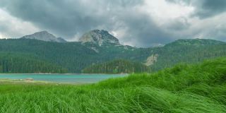 美丽的高山湖岣梢湖在奥地利阿尔卑斯山脉，有绿色的草地和多云的天空。间隔拍摄4 k。