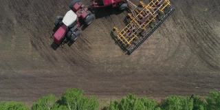 鸟瞰图的拖拉机在田地里工作，播种和犁地的同时