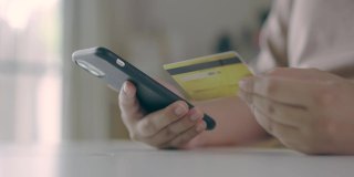 女手用手机进行网上购物，通过信用卡支付