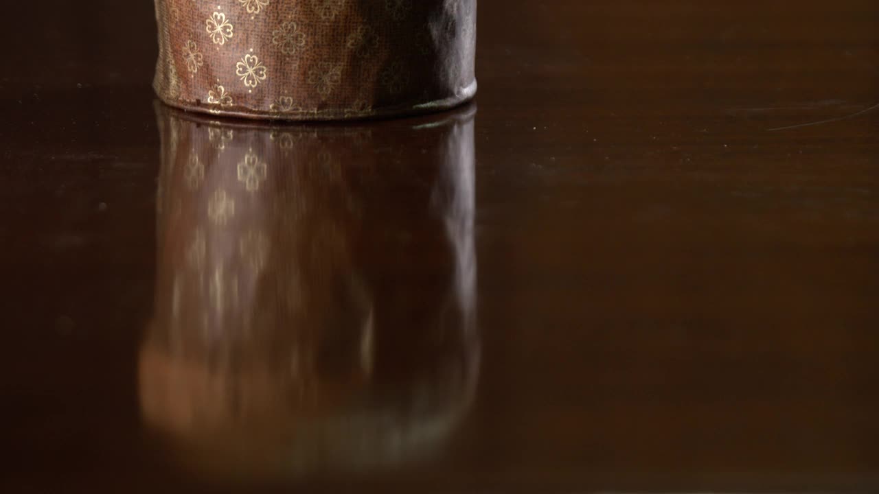 潘妮朵妮坐在木桌上，背景是棕色的木质纹理。