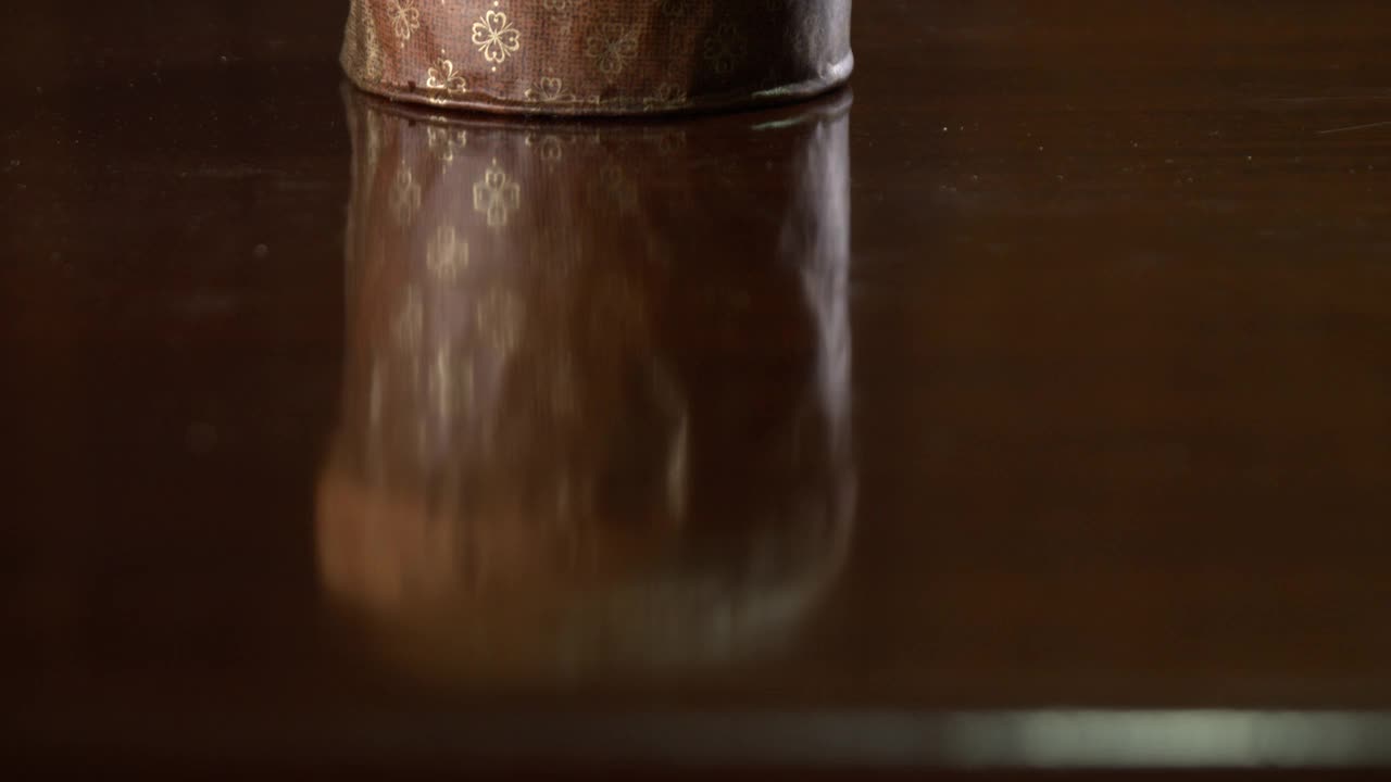 潘妮朵妮坐在木桌上，背景是棕色的木质纹理。