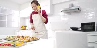 4K亚洲女人面包店老板正在接受客户的订单在手机上。