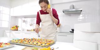 4K亚洲女人面包店老板正在接受客户的订单在手机上。