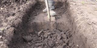 人挖了一个深坑。用铁锹挖坑。