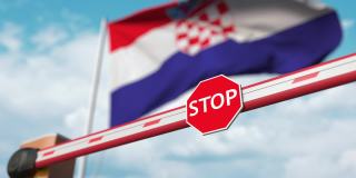 在克罗地亚国旗前开有停止标志的栅栏