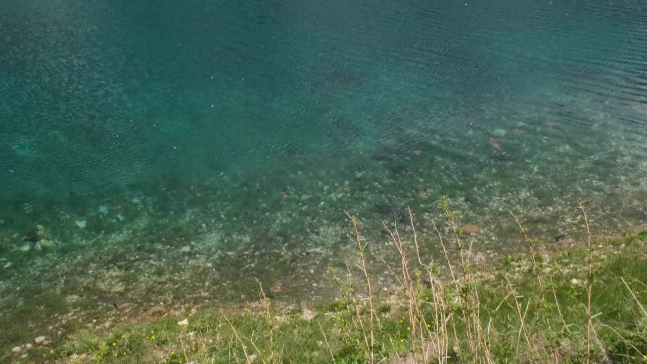 高耸入云的卡雷扎湖。阿尔卑斯山的一个可爱的地方。水中的倒影。阳光明媚的春天。倾斜。Trentino Alto Adige. 4K UHD 59.94fps ProRes 422 HQ 10位