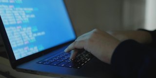慢动作场景程序员在笔记本电脑键盘上打字，将代码语言输入到软件中，以研究办公系统的bug和缺陷，以开发技术概念