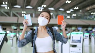 封城结束后，幸福女性再次享受旅行，年轻的亚洲女性在机场候机楼用清新爽朗的背包休闲布微笑着挥手欢迎旅行理念视频素材模板下载