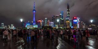 时间流逝:在上海外滩观光景点，人们在陆家嘴摩天大楼灯光秀上散步并拍照。