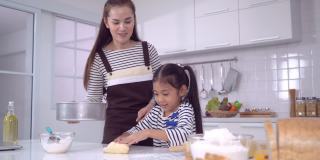 妈妈和孩子一起在家庭厨房做面团和烘焙，为家庭乐趣的概念。