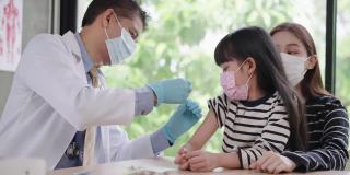 感受少女对针头的恐惧，亚洲资深男医生戴着卫生口罩在亚洲患者的手臂上注射疫苗，一个孩子带着姐姐一样的朋友过来，表景