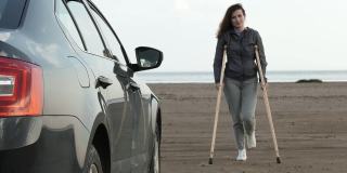 一名拄着拐杖的残疾妇女试图上车。拐杖从女人手里掉下来。