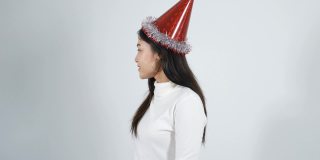 快乐的年轻女人戴着帽子，拿着白色背景上的红色圣诞礼盒