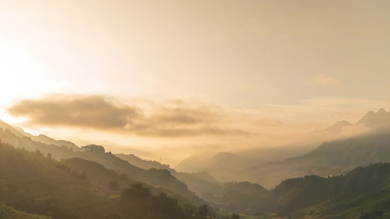 时光流逝，日落山峦，风景秀丽薄雾，黄昏金色时光，天空戏剧性。时光流逝美丽的风景运动高山山脊薄雾平移全景风景黎明戏剧性的天空。