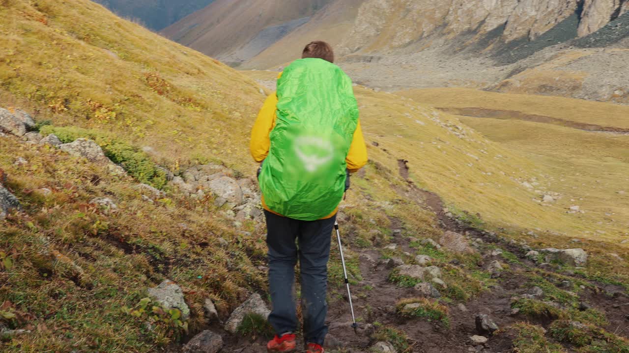 一名背包客在吉尔吉斯斯坦风景如画的山谷徒步旅行