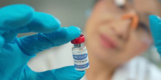 女科学家手里拿着安瓿，新药研发，疫苗接种，COVID-19冠状病毒疫苗瓶。