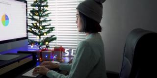 亚洲妇女用电脑装饰她的客厅为圣诞节。