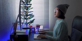 年轻的亚洲妇女在平安夜使用电脑。