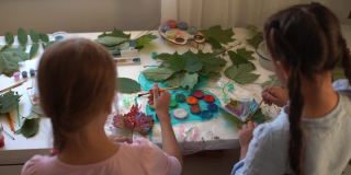 给孩子们的秋季工艺品。用枫叶做成的动物狐狸。儿童艺术和创造力。天然材料制成的工艺品。女孩用颜料画画。