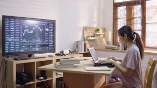 亚洲女性工作在家里作为交易员和财务顾问使用笔记本电脑做她的家庭预算视频素材模板下载