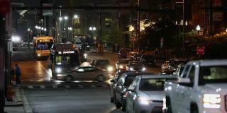 巴尔的摩晚间城市街。公共交通巴士，日常交通和街灯背景。马里兰