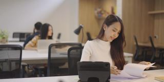 亚洲女性在办公室共享办公空间工作。