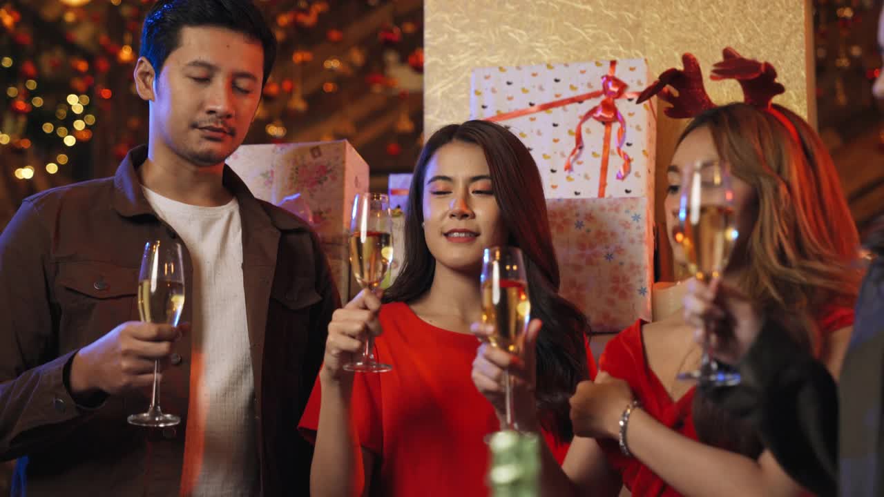 一位亚洲商务同事在平安夜的派对上用香槟畅饮
