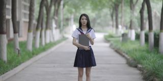 年轻的亚洲女人拿着笔记本电脑