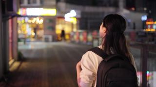 年轻的旅行者走在夜城的街道上视频素材模板下载