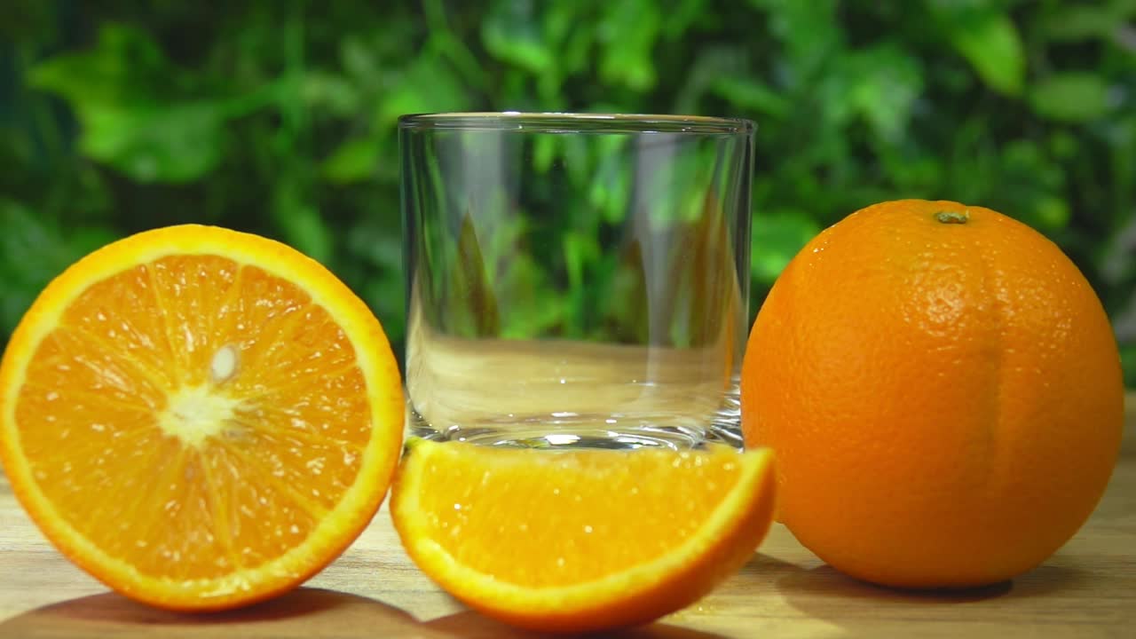橙汁倒在玻璃杯里，旁边是切成大块的橙子