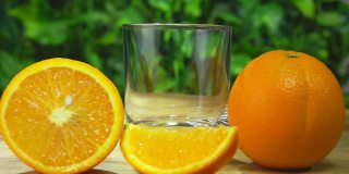 橙汁倒在玻璃杯里，旁边是切成大块的橙子