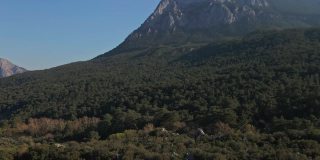 无人机在大山下的野生森林上空飞行的鸟瞰图。安塔利亚和落基山脉的蓝天美景