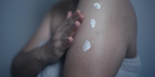 深色皮肤的女性会在皮肤上涂抹护肤霜。