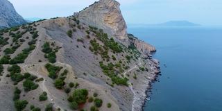 在克里米亚海径加利亚四轴飞行器从空中蓝天山野绿树度假山全景，旅游黑岩峰绿色，山顶海景海滩，悬崖海顶视图克里米亚山