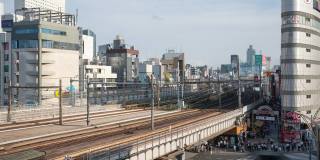 4K延时:鸟瞰图的旅行者行人拥挤的十字路口和火车移动在Ameyoko市场在东京上野。