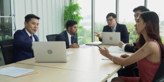 亚洲商务人士会议小组会议在办公室举行。在工作场所进行团队讨论。公司同事讨论财务问题。会议准备工作