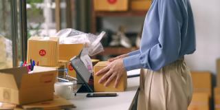女工用胶带密封纸箱包装电子商务发货订单箱。