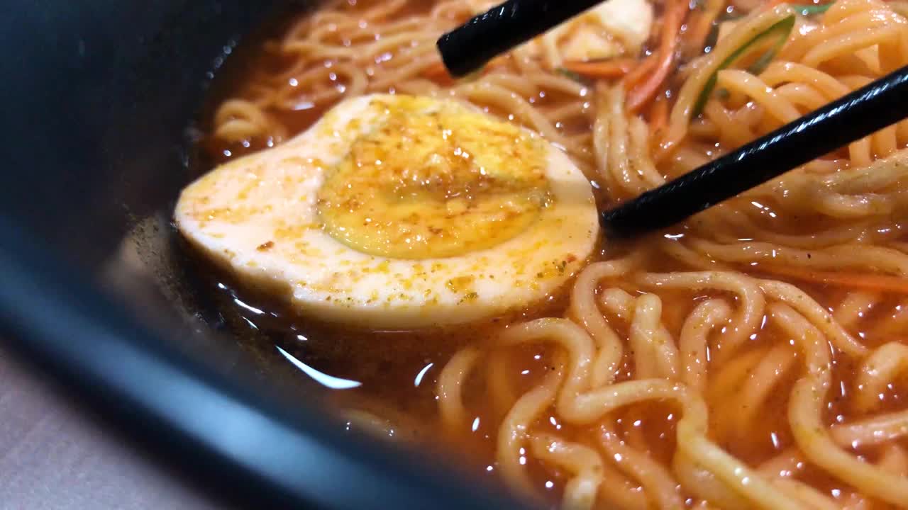 红辣拉面，鸡蛋和饺子在黑色的碗