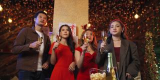 一群朋友在晚上一起庆祝新年倒计时，用香槟酒碰杯