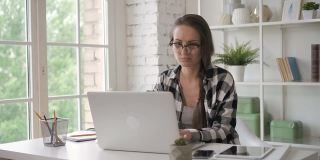 女企业主工程师在现代办公室投资笔记本电脑。女售货员