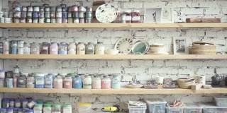 室内艺术工作室的架子上摆放着各种颜色的罐子