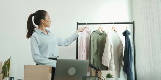 一位亚洲企业家正在准备可以装在纸盒里卖给顾客的衣服。