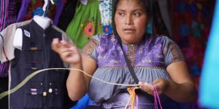 年轻的墨西哥妇女正在刺绣当地典型的衬衫和衬衫