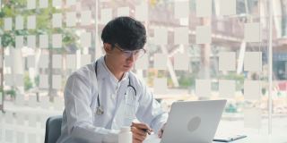 亚洲医生在病毒爆发期间为患者提供在线咨询，保持社交距离。